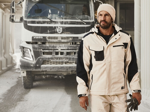 Workwear Winter Softshelljacke JN824 Mann auf der Baustelle ausen mit Daiber Winter Softshelljacke JN824 in beige