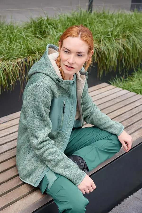 Daiber JN1874 Strick-Fleecejacke Unisex mit Dame in grüner Farbvariante beim Outdoor-Lifestyle