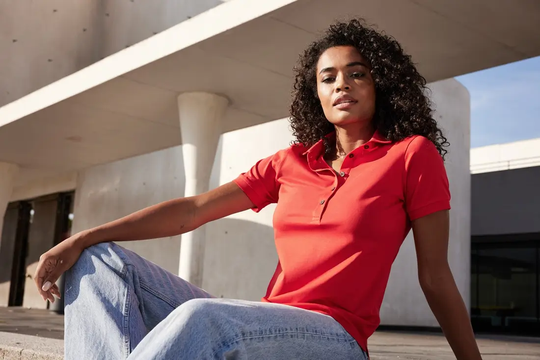 Frau mit Daiber Poloshirt JN1301 in der Farbe rot sitzend