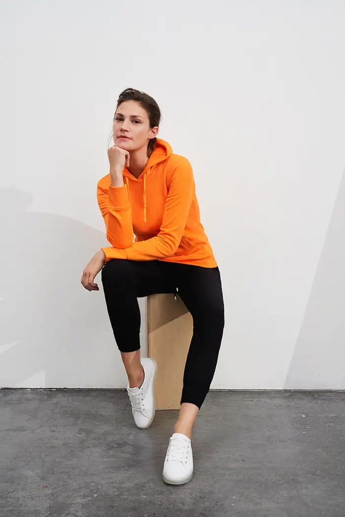 Frau trägt Damen Kapuzensweatshirt Daiber Slim Fit in klassischer Pose, Kapuze, Kängurutasche, Farbe orange