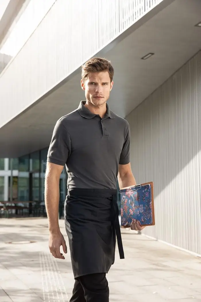 Mann bei der Arbeit in der Gastronomie trägt kurzarm Poloshirt in der Farbe carbon, Lifestyleaufnahme